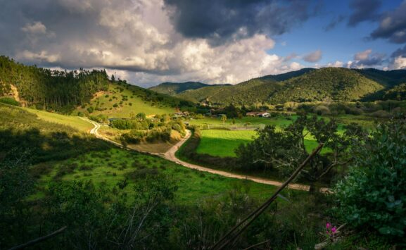 Lush green valley in the Algarve mountains under spring skies