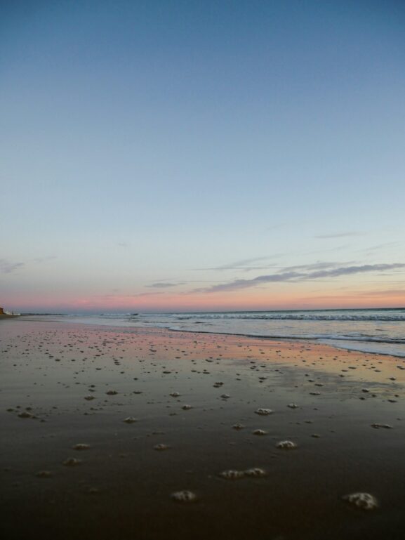 Morning light over an Algarve beach and nearby coastal walking cliffs.