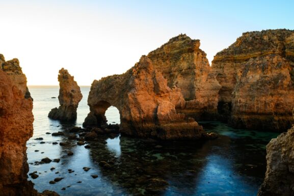 Golden limestone rock formations at Ponta da Piedade with turquoise water and dramatic sea arches near Lagos